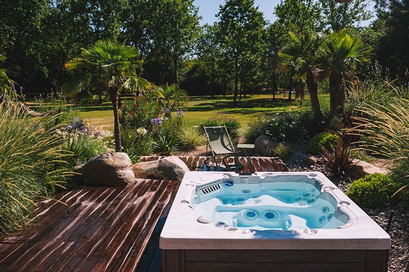 Terrasse en bois autour d'un spa, aménagement de jardin haut de gamme par Rokaï Paysagiste à Noirmoutier